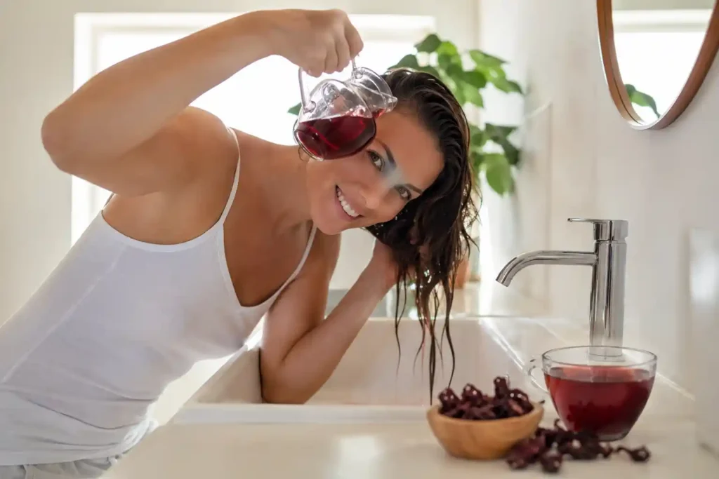 Woman using hibiscus tea as hair rinse for natural hair growth and strength